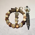 Blessed Bead worx beaded wristlet keychain and crystal-encrusted pen set in brown, cream, and gold tones.