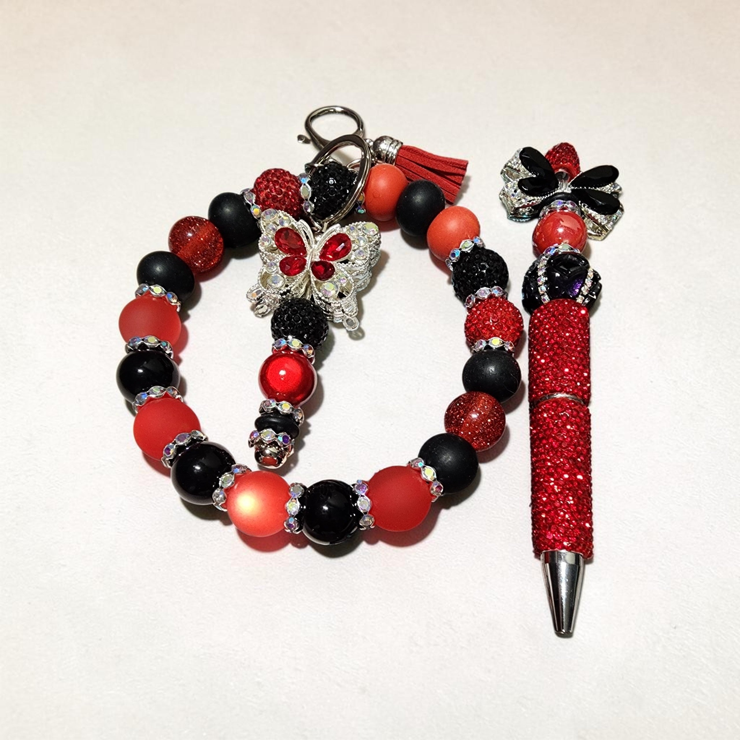 Blessed Bead worx red and black beaded pen and keychain set featuring butterfly charms and sparkling rhinestones.